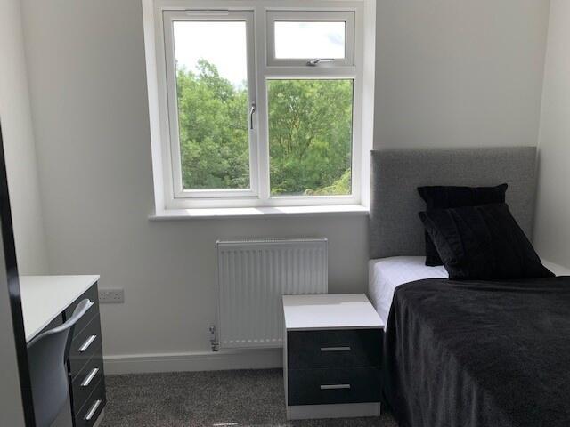 A bright and neat single bedroom featuring a co...