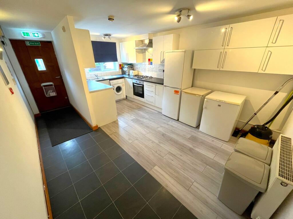 A bright and modern kitchenette with ample stor...