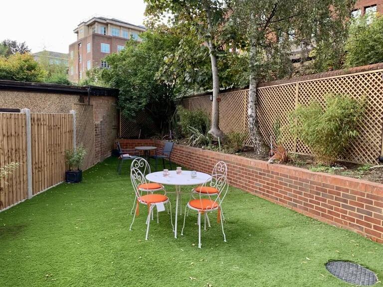 A well-maintained garden featuring a neat artif...
