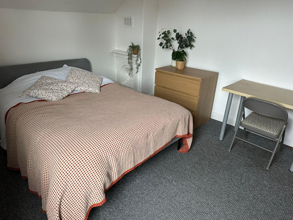 A cozy double bedroom featuring a comfortable b...