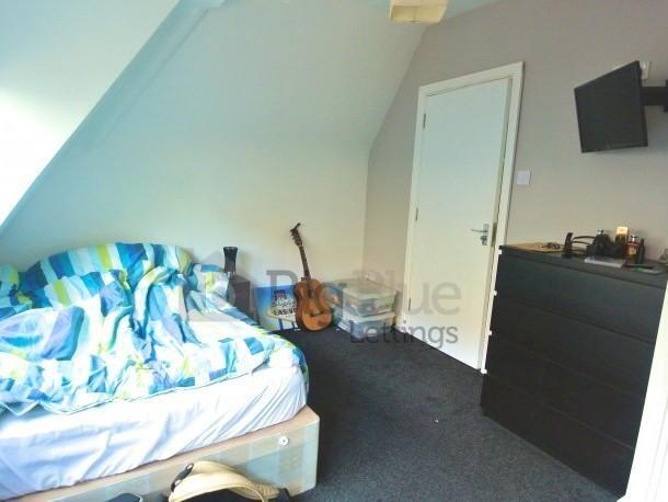 Cozy single bedroom featuring a comfortable bed...