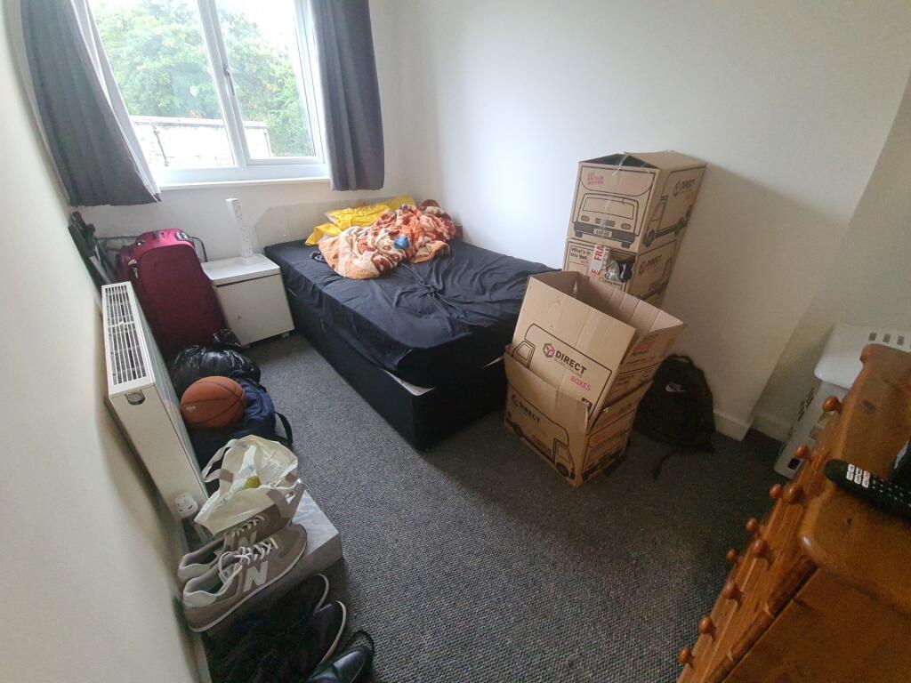 Cozy single bedroom featuring a large window wi...