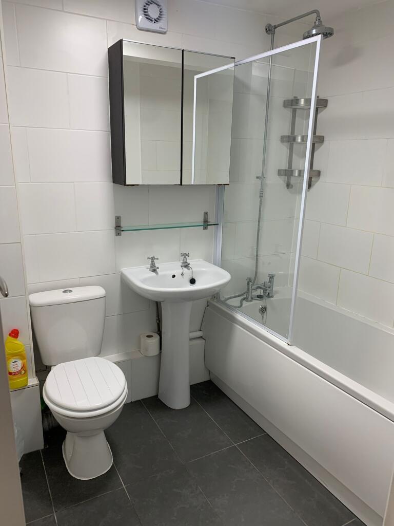 Bright and clean bathroom suite featuring a mod...