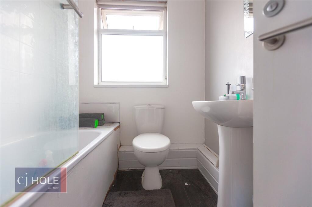 A clean, modern bathroom featuring a bathtub wi...