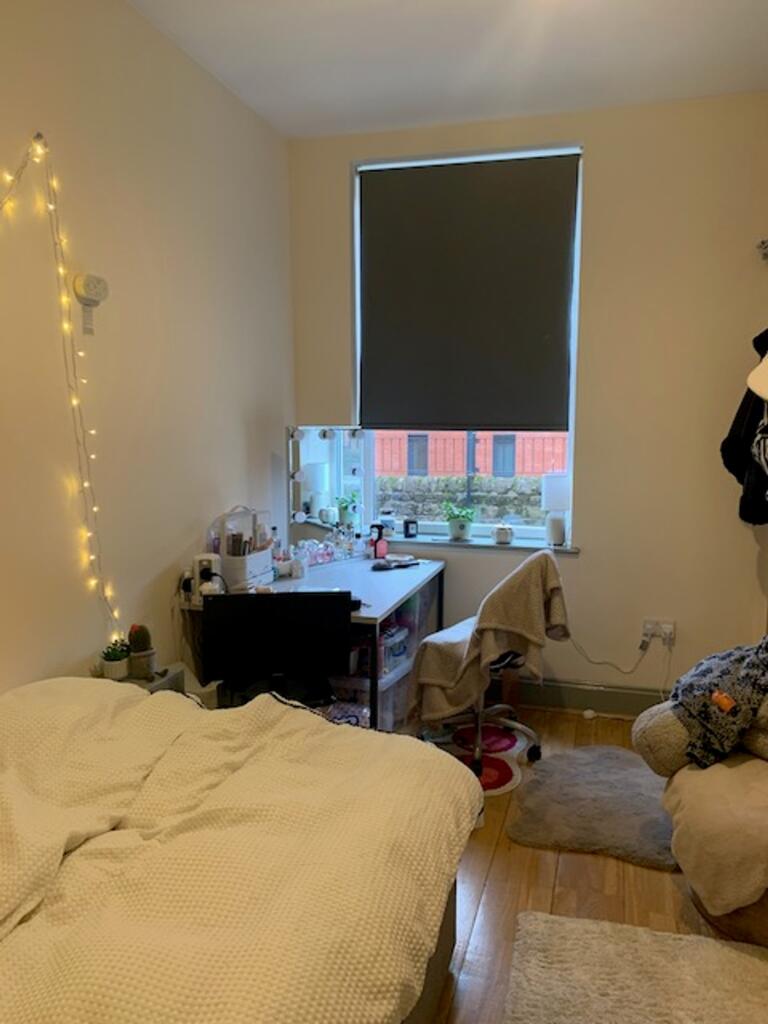 A cozy double bedroom with a well-arranged stud...