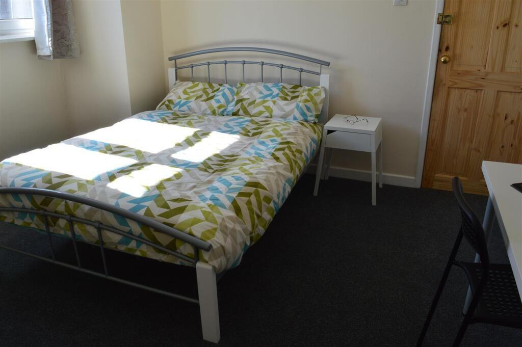 Comfortable double bedroom featuring ample natu...