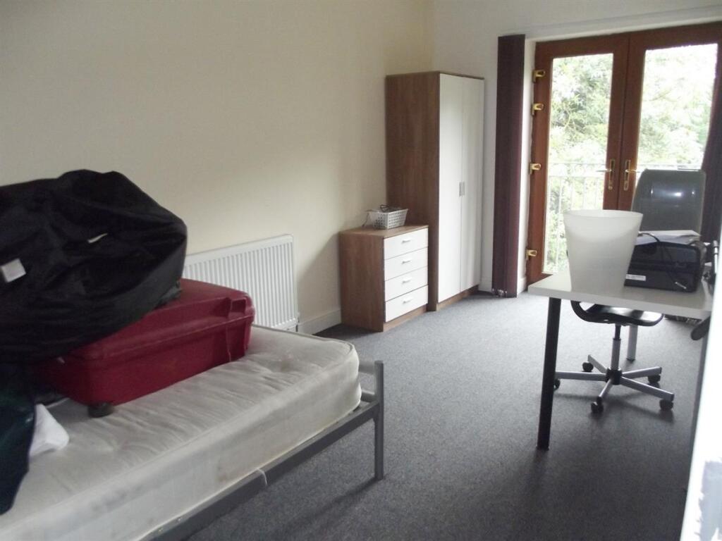 A spacious bedroom featuring a single bed frame...