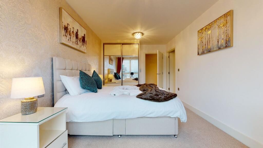 A bright and elegant master bedroom featuring a...