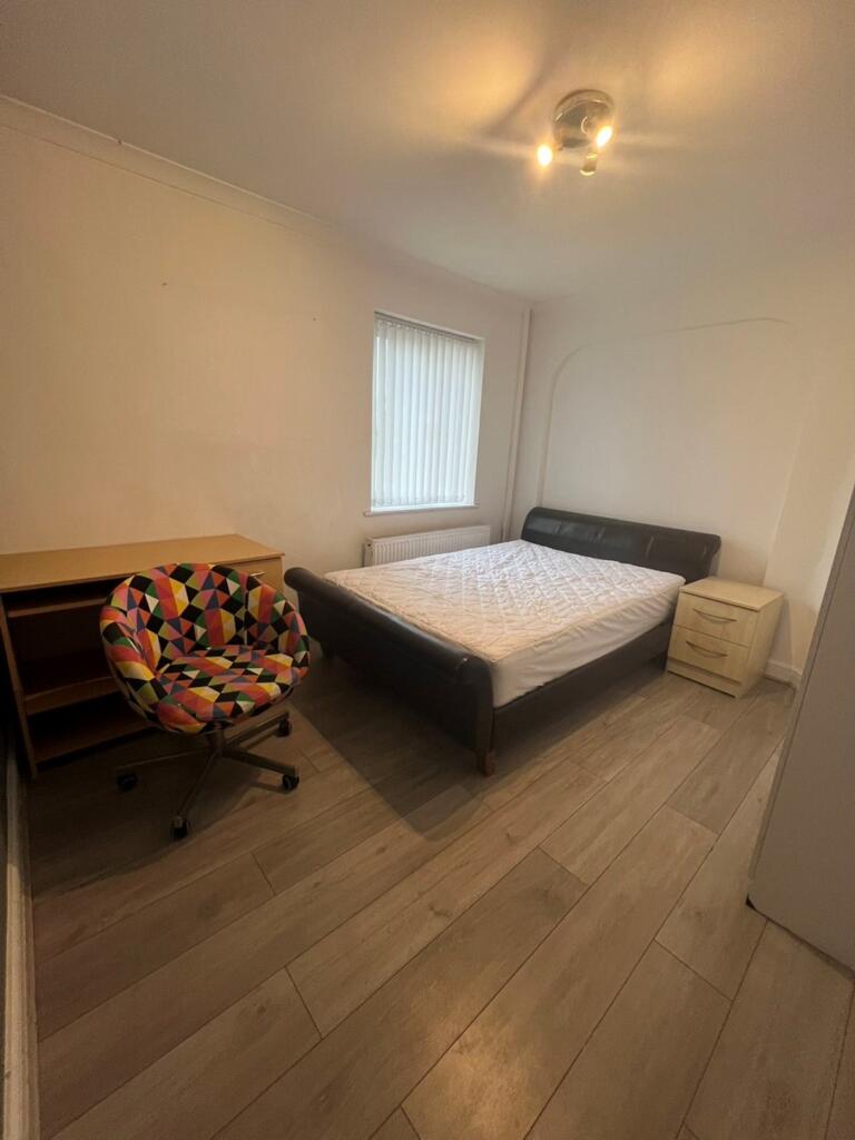 A spacious and tidy double bedroom featuring am...