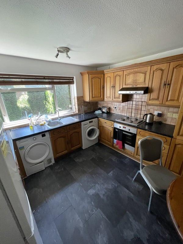 Bright kitchen featuring wooden cabinetry, blac...