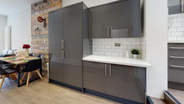 Modern kitchen featuring sleek grey cabinets wi...