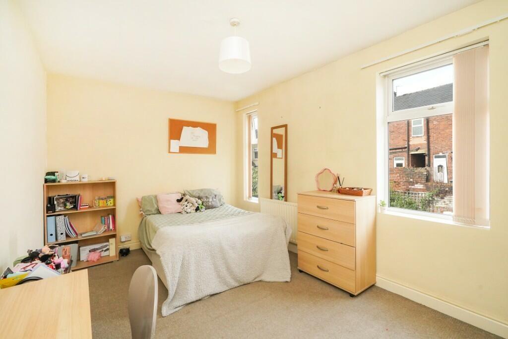 A bright and tidy bedroom featuring a comfortab...