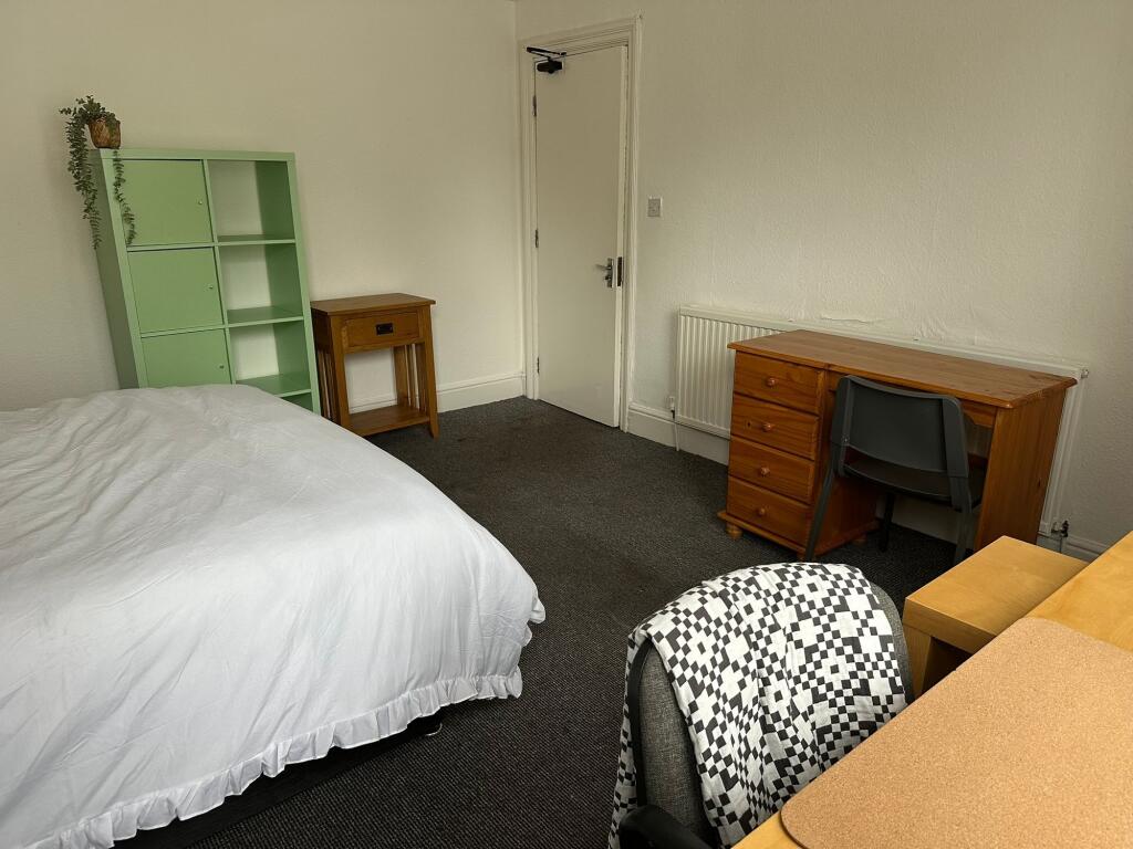 A cozy student bedroom featuring a double bed w...
