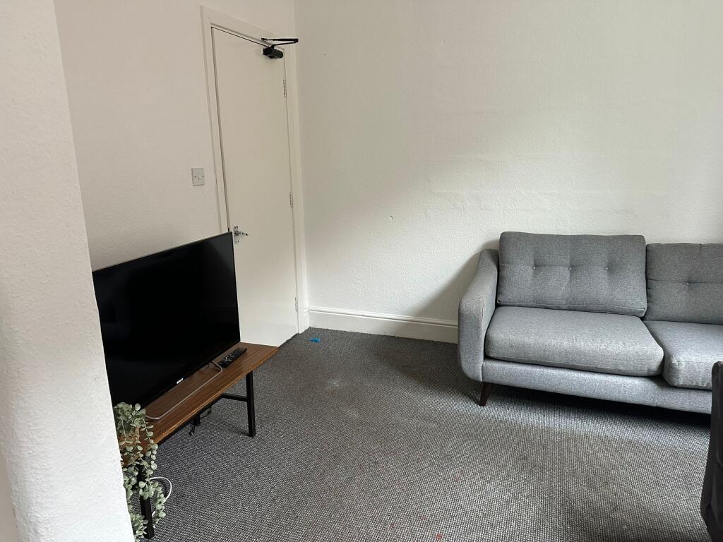 A spacious and clean living room featuring a co...