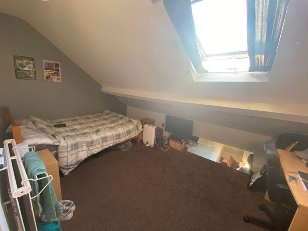 A cozy double bedroom featuring a skylight that...