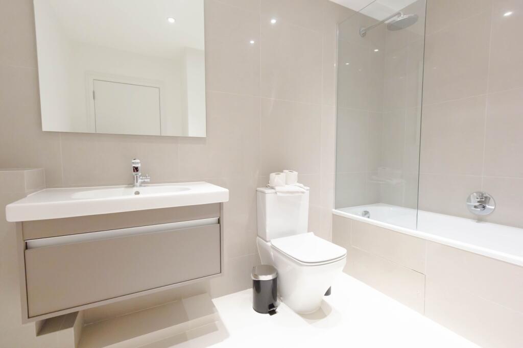 A modern and pristine bathroom featuring a slee...
