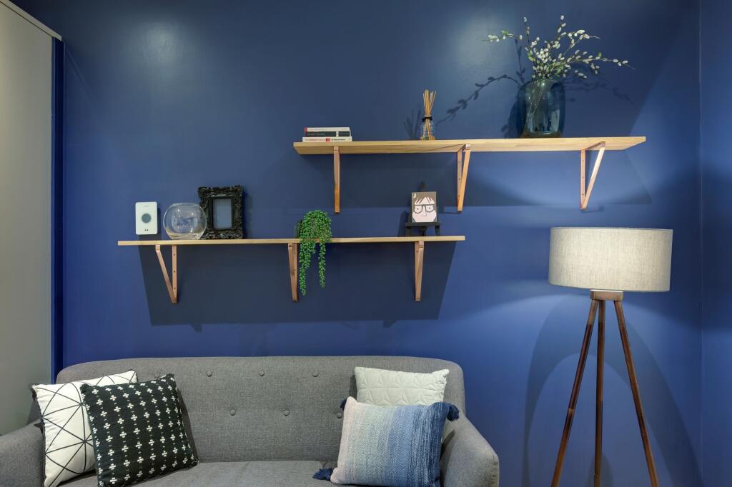 Charming living room featuring a vibrant blue a...