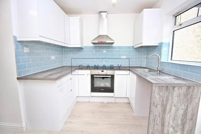 Bright and modern kitchen featuring clean white...
