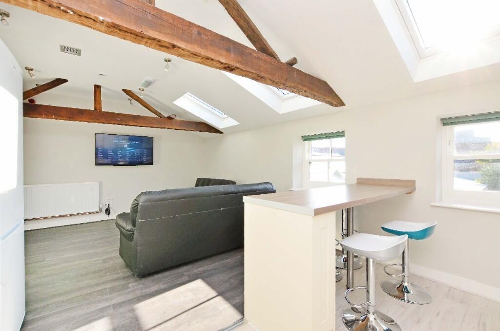 Bright and airy living space featuring exposed ...
