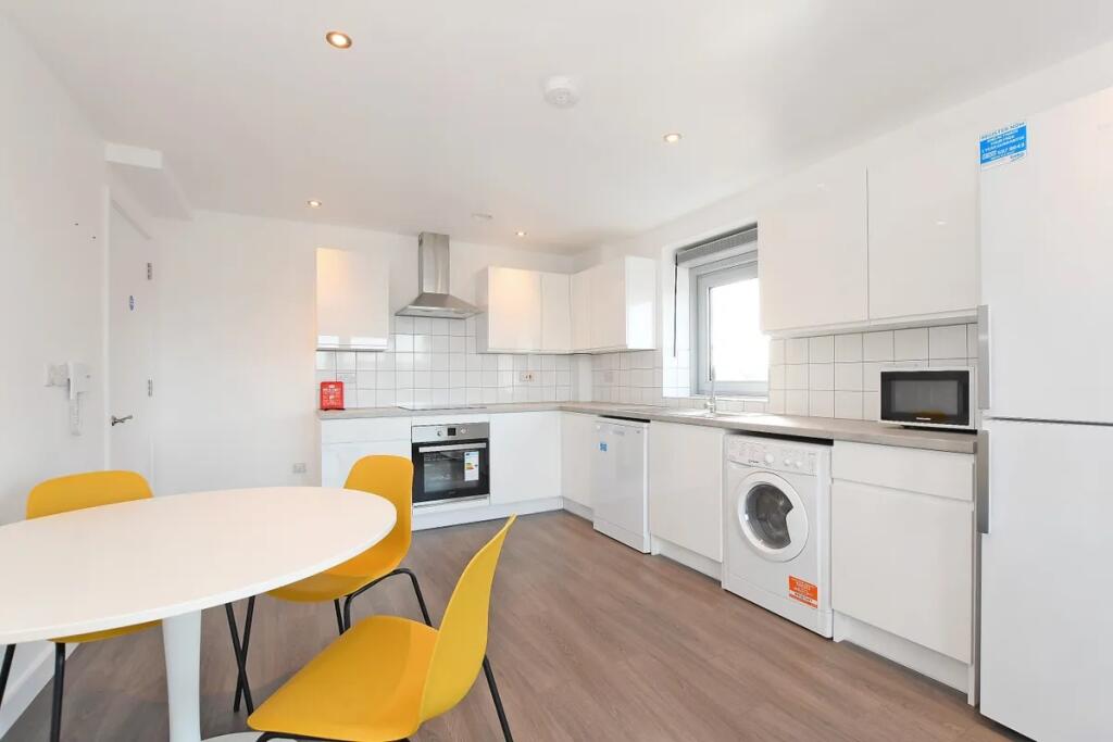 Bright and modern kitchen featuring sleek white...