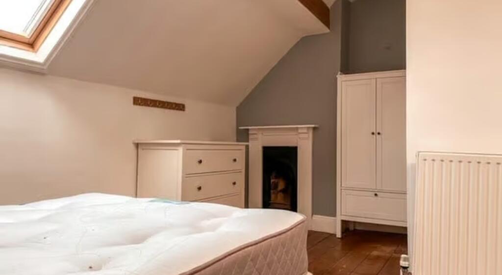 A cozy double bedroom featuring a bright skylig...