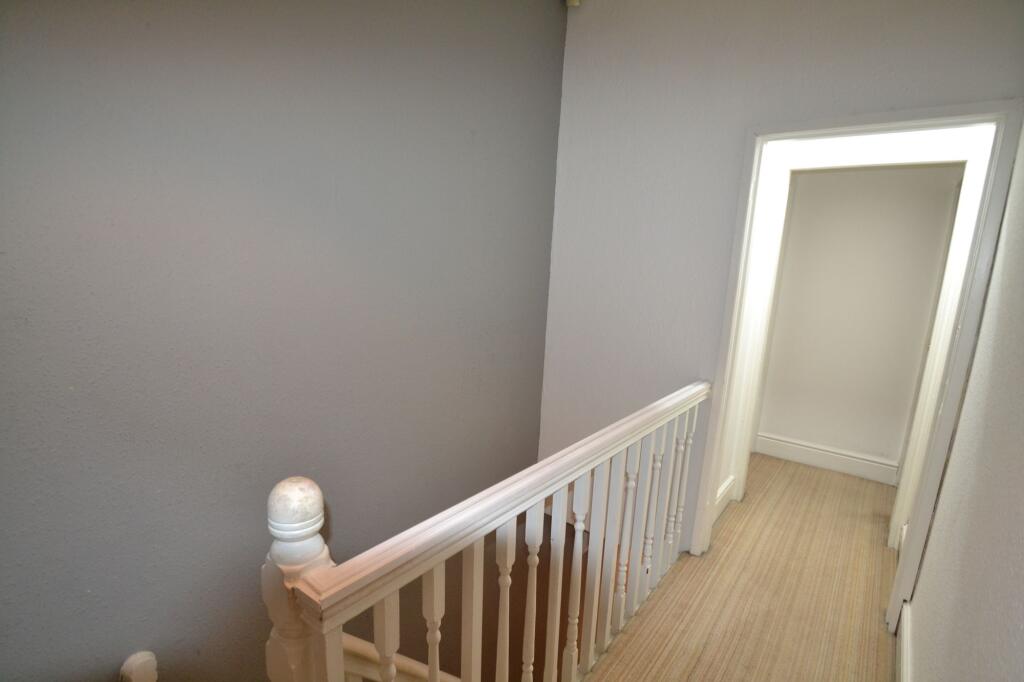 A clean and simple hallway with white walls and...