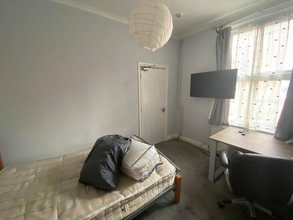 A cozy and well-lit double bedroom with a comfo...