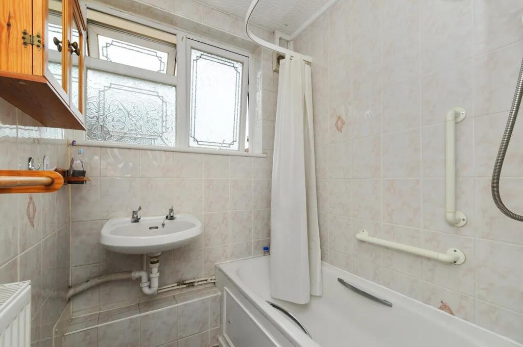 Bright and clean bathroom suite featuring a ful...