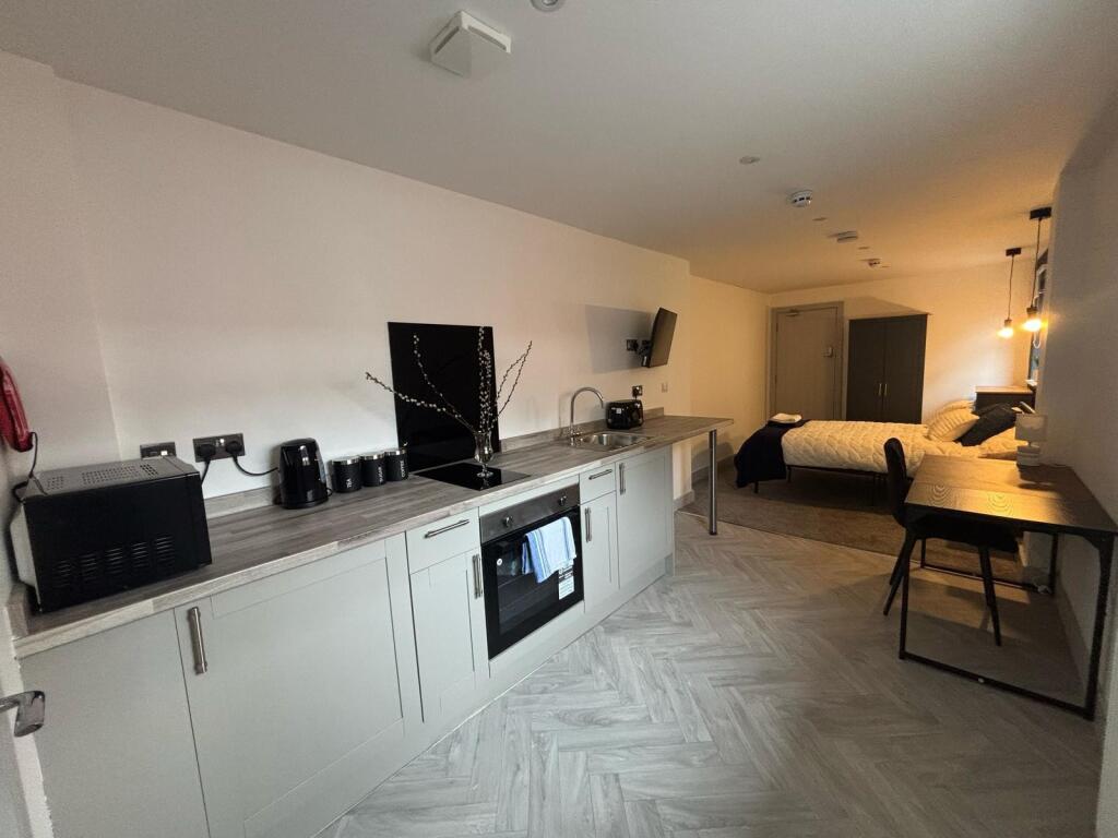 Modern kitchenette featuring sleek cabinetry an...