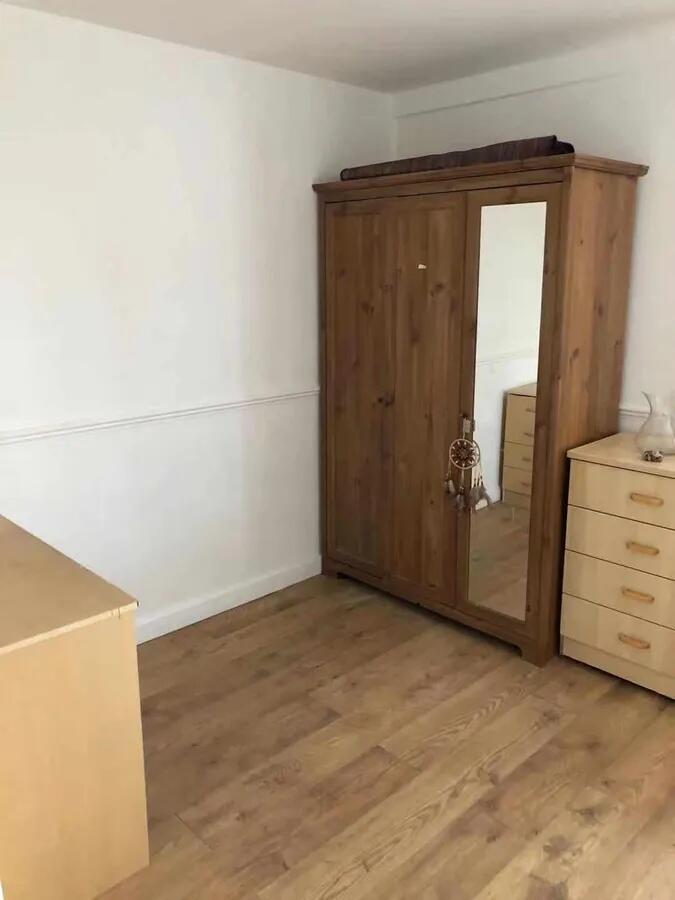 A tidy double bedroom featuring wooden flooring...