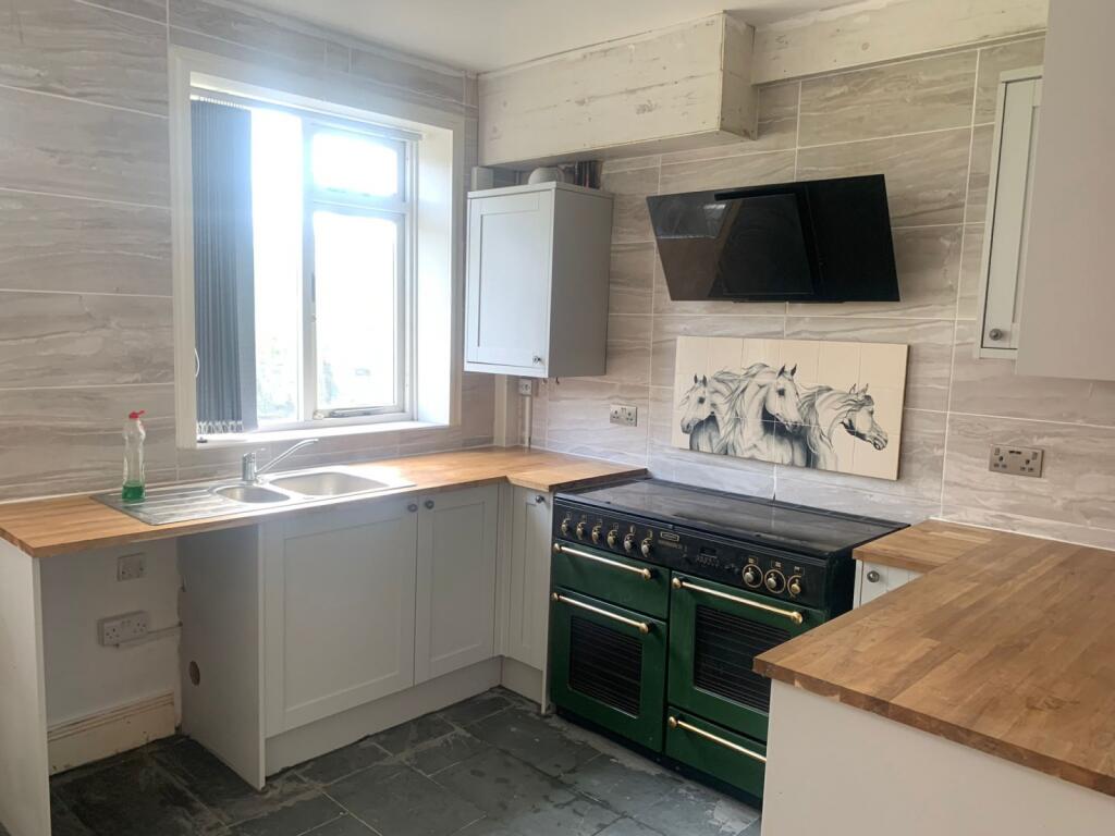 Bright and modern kitchen featuring a large win...