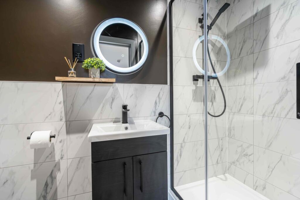 Modern bathroom featuring a sleek white sink wi...