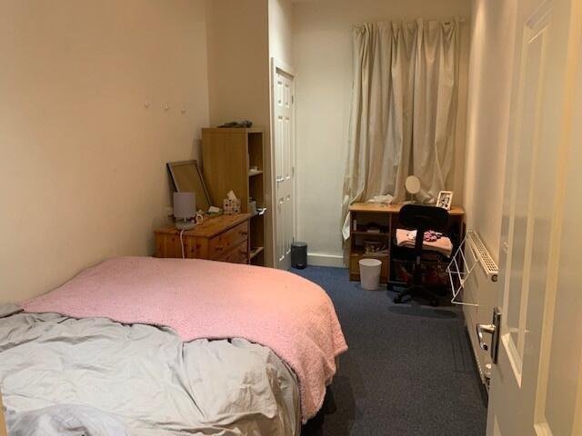 Cosy furnished bedroom with a double bed, bedsi...