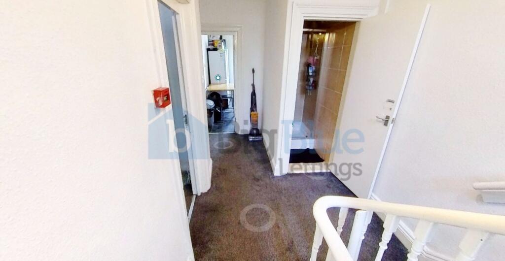 A well-kept hallway with neutral walls and carp...
