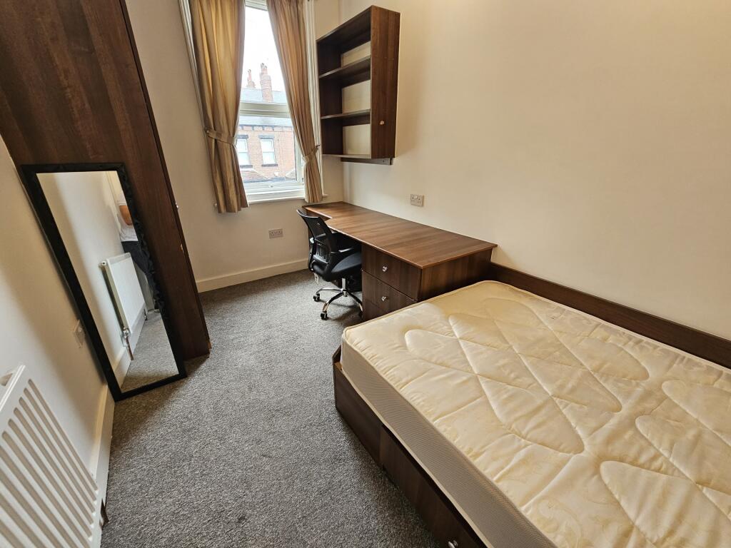 A neat and functional single bedroom featuring ...