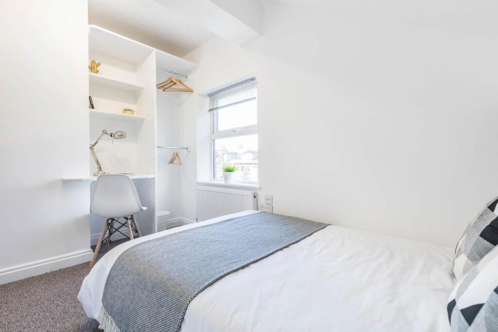 Bright and tidy bedroom featuring a comfortable...