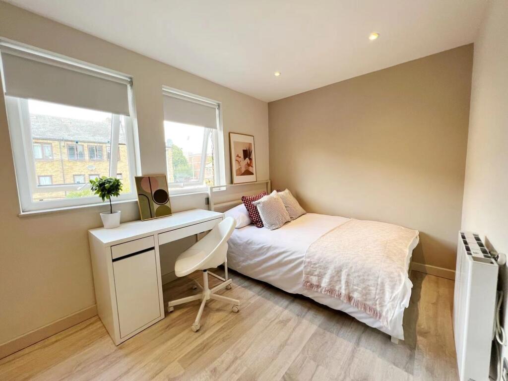 Bright and cozy single bedroom featuring a comf...