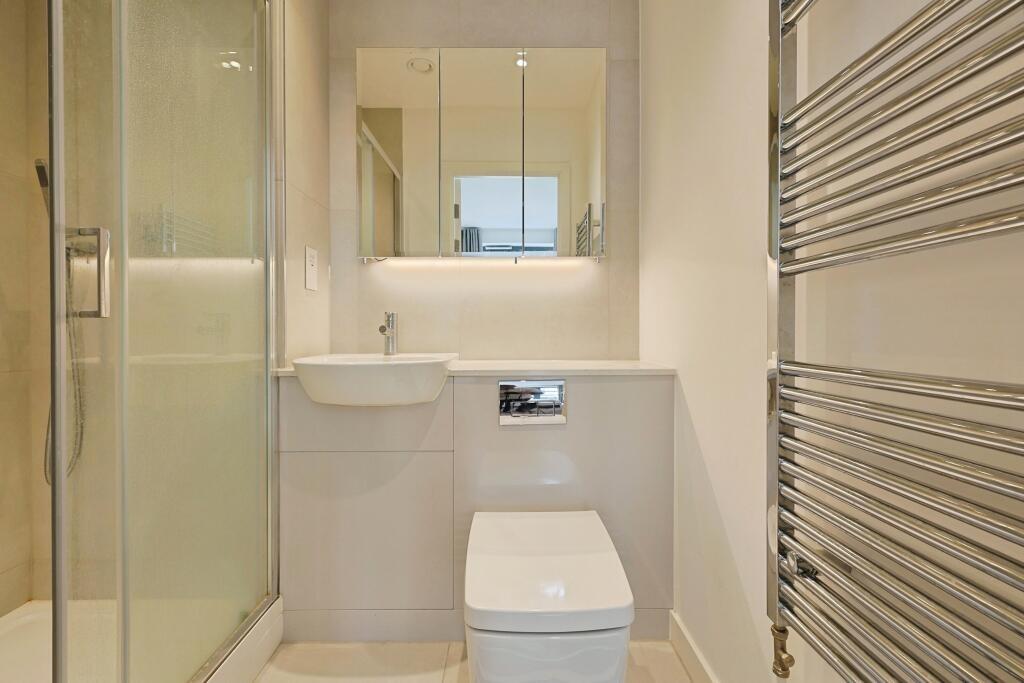 Modern, compact bathroom featuring a sleek toil...