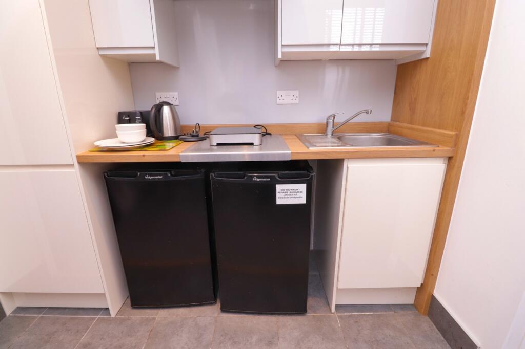 A sleek and tidy kitchenette featuring modern a...