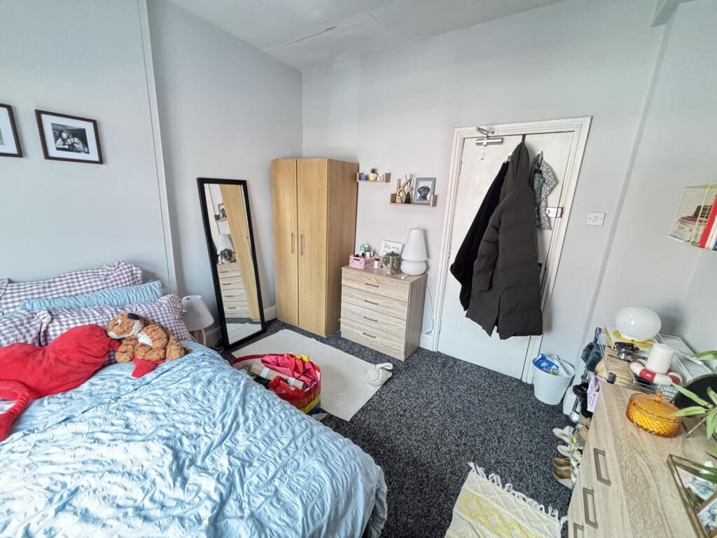 A cozy bedroom featuring a neatly made bed with...