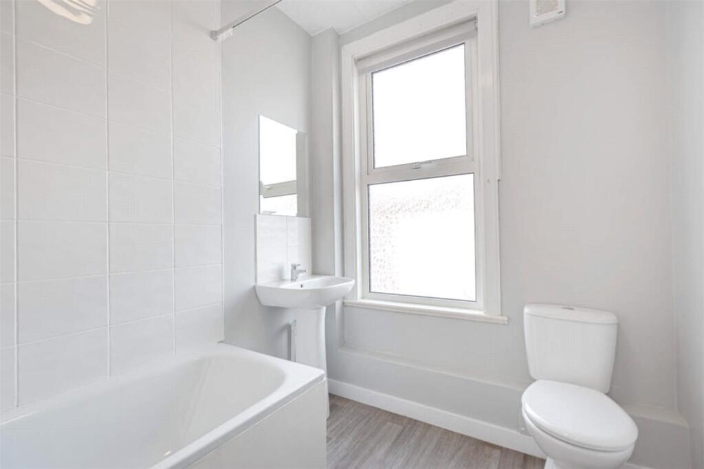 Bright and modern bathroom featuring a spacious...