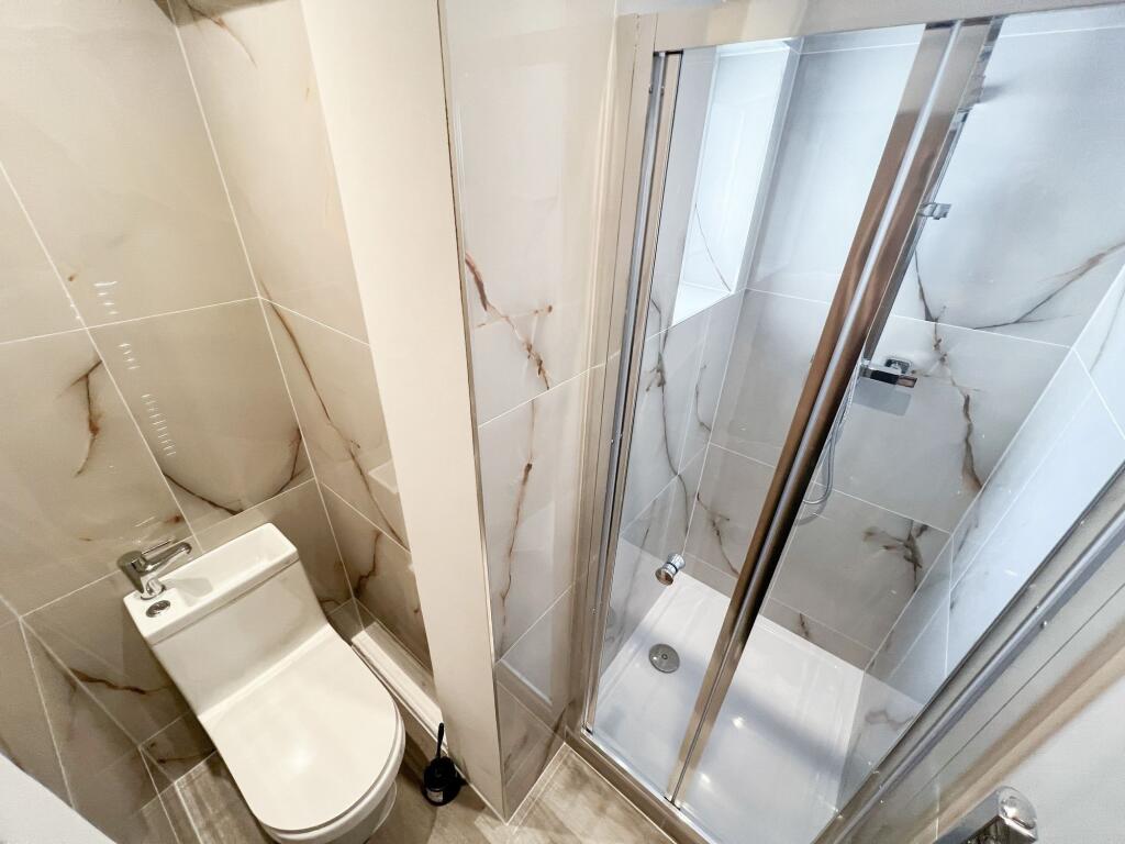 A modern bathroom featuring a sleek walk-in sho...