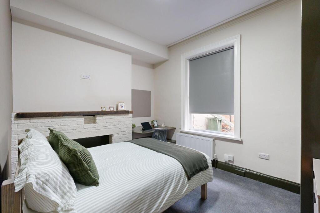 A bright and tidy bedroom featuring a comfortab...