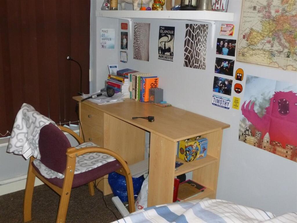 Cozy bedroom corner with a wooden desk, shelvin...