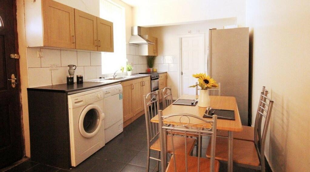 A well-lit kitchen area featuring a compact arr...