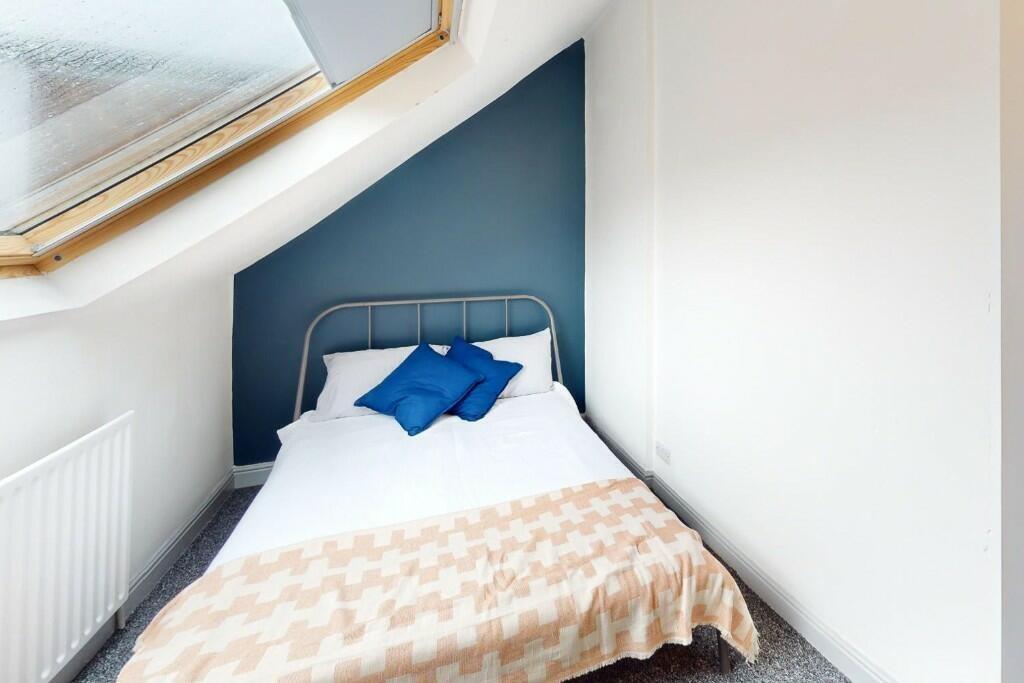 Cozy single bedroom featuring a comfortable bed...