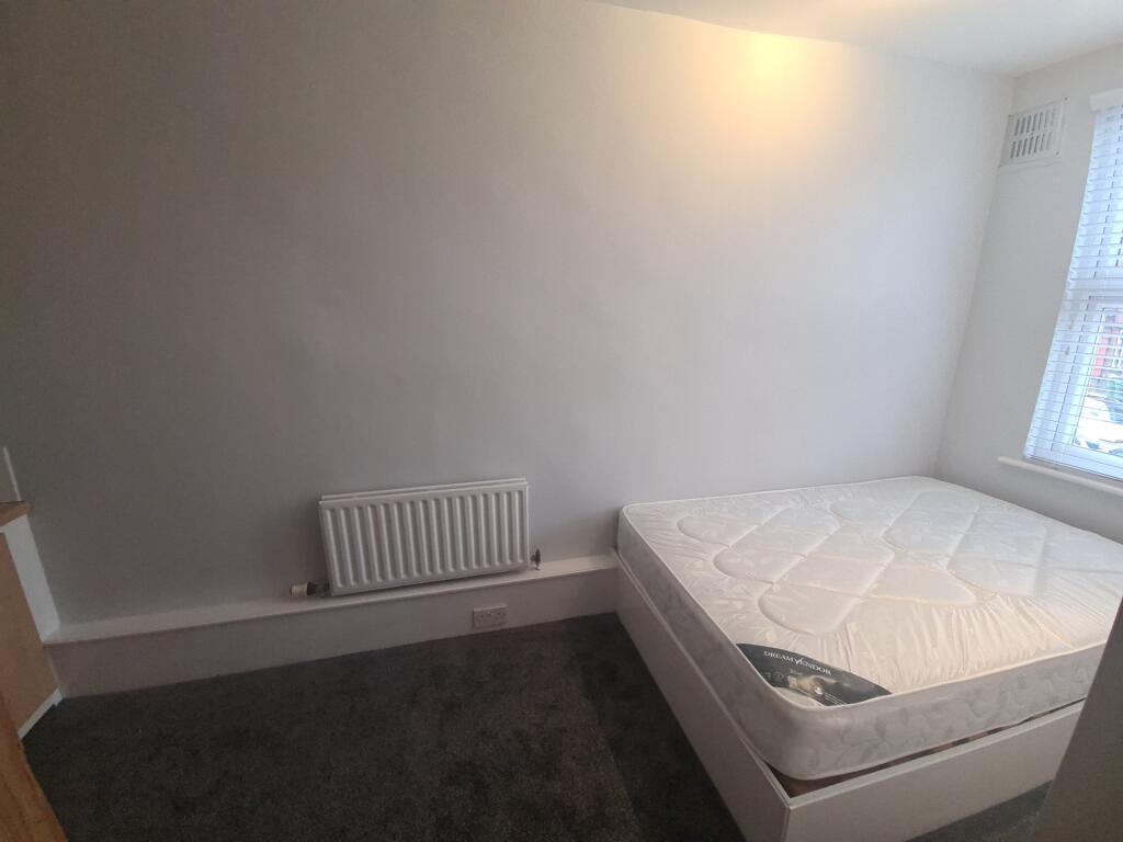 A neat and simple bedroom featuring a comfortab...