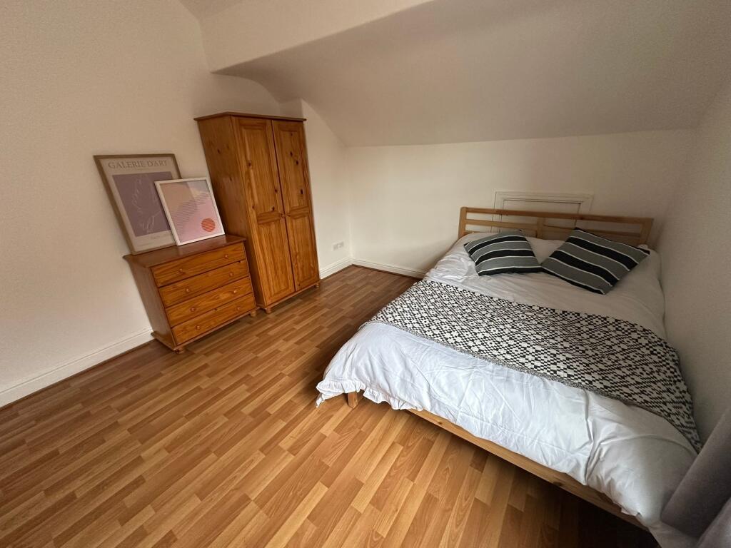 A tidy, well-lit double bedroom featuring a com...