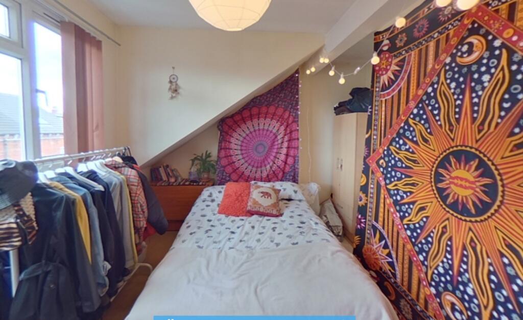 Cozy single bedroom with vibrant tapestry wall ...