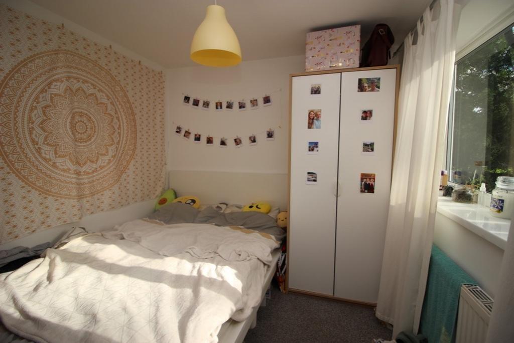 A cozy single bedroom featuring a comfortable b...